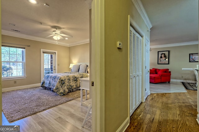 bedroom featuring a ceiling fan, baseboards, ornamental molding, and wood finished floors