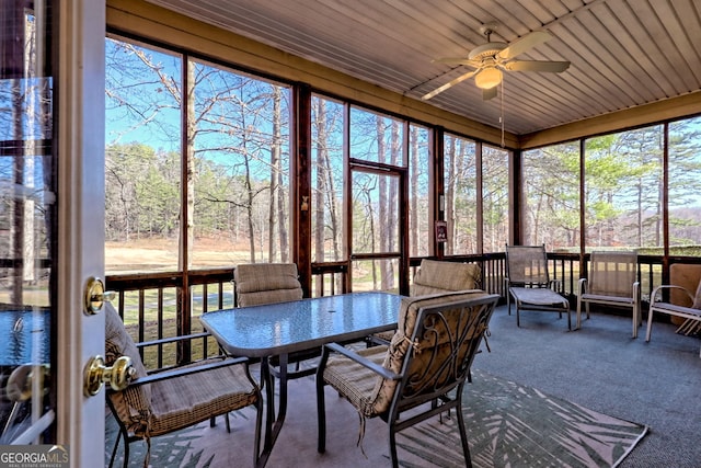 sunroom / solarium featuring plenty of natural light and a ceiling fan