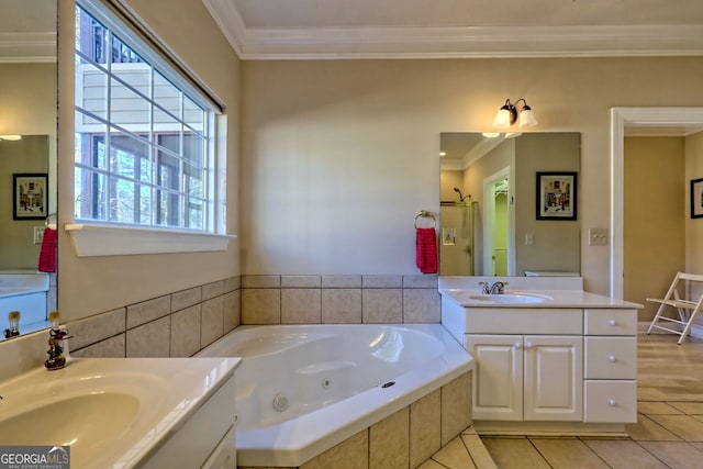 full bathroom featuring ornamental molding, a jetted tub, a sink, and tile patterned floors