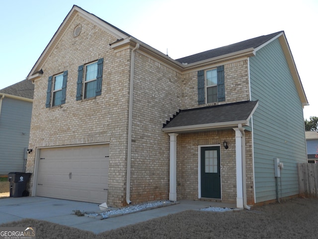 traditional-style house featuring concrete driveway, brick siding, and an attached garage