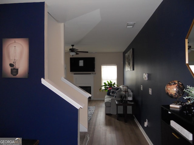 corridor with baseboards, visible vents, and wood finished floors