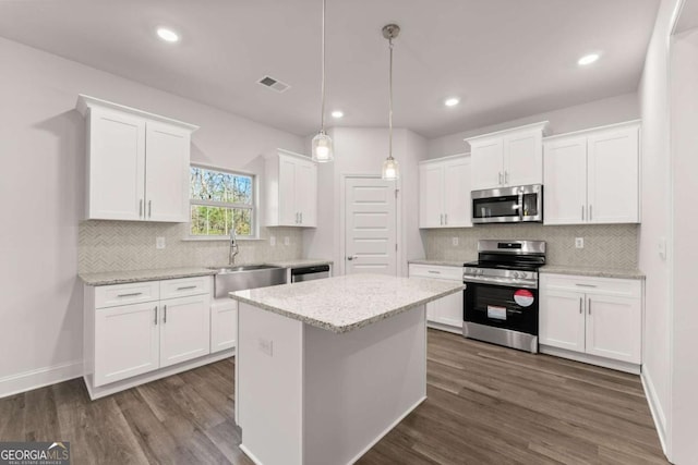 kitchen with white cabinets, visible vents, stainless steel appliances, and a sink