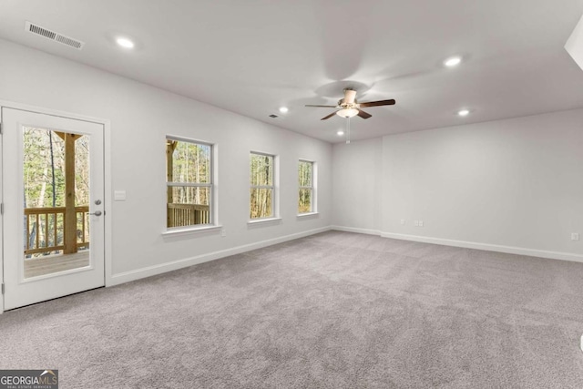 carpeted empty room with baseboards, visible vents, and recessed lighting