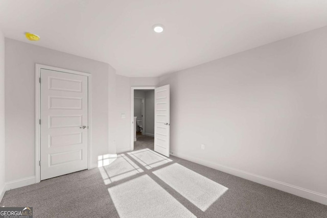 unfurnished bedroom featuring carpet floors and baseboards