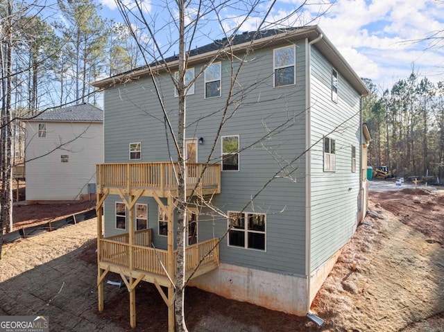 rear view of house featuring a wooden deck