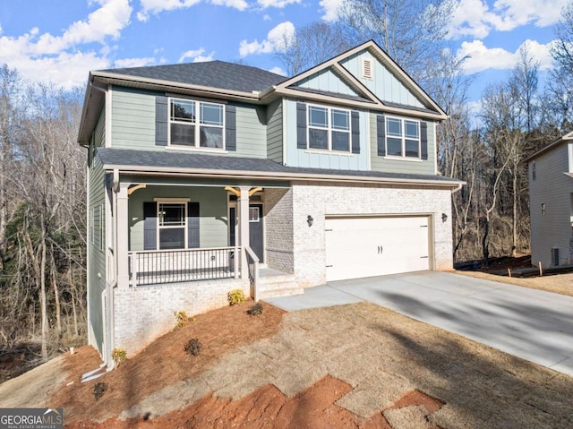 view of front of home with an attached garage, covered porch, brick siding, driveway, and board and batten siding