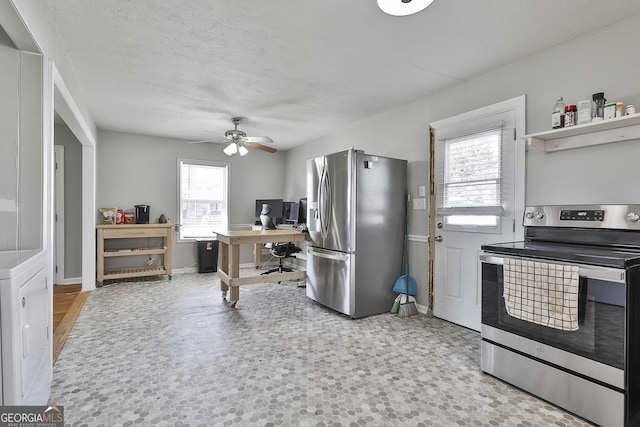 kitchen with ceiling fan, a textured ceiling, stainless steel appliances, baseboards, and washer / dryer