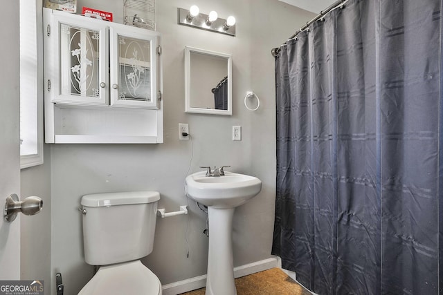 full bathroom featuring curtained shower, a sink, and toilet