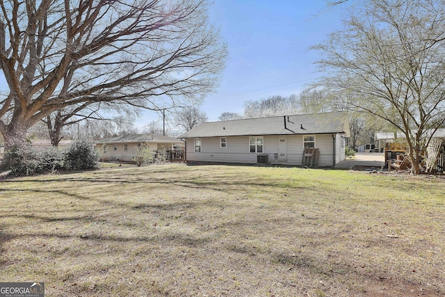 rear view of house with a yard and central air condition unit