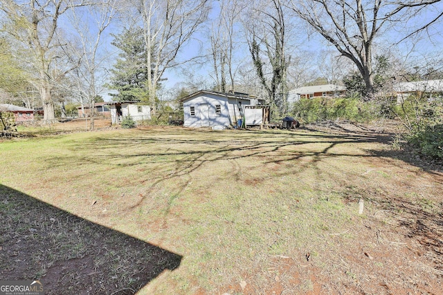 view of yard featuring an outdoor structure and fence