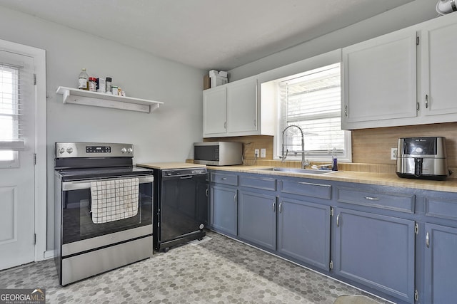 kitchen featuring stainless steel appliances, a sink, light countertops, and blue cabinets