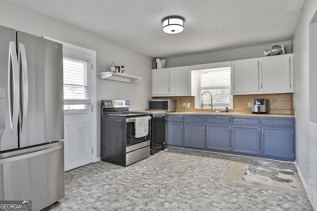 kitchen featuring white cabinetry, plenty of natural light, appliances with stainless steel finishes, and a sink