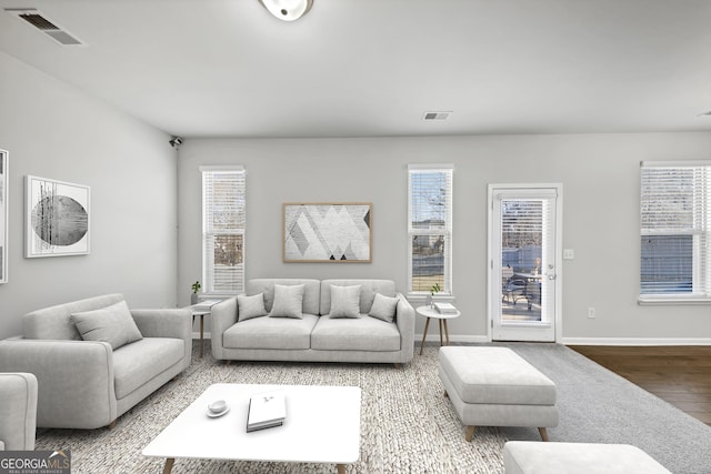 living room with a healthy amount of sunlight, visible vents, and wood finished floors