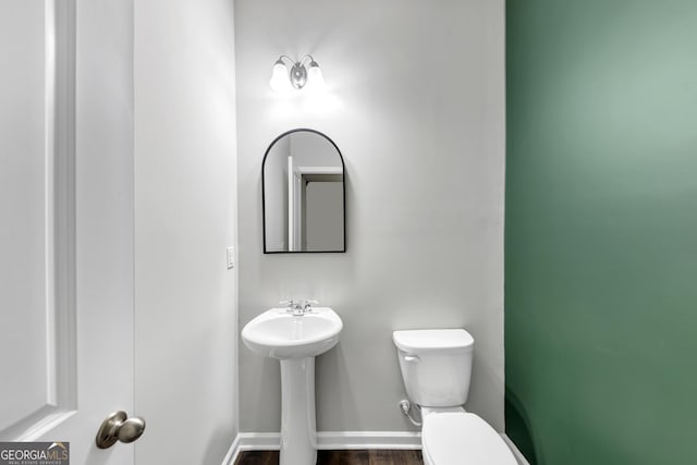 bathroom featuring wood finished floors, toilet, and baseboards