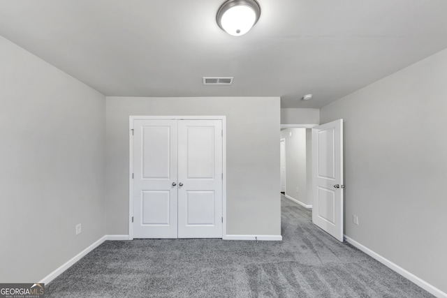 unfurnished bedroom featuring carpet, a closet, visible vents, and baseboards