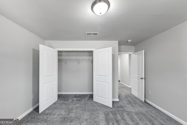 unfurnished bedroom featuring a closet, carpet flooring, visible vents, and baseboards