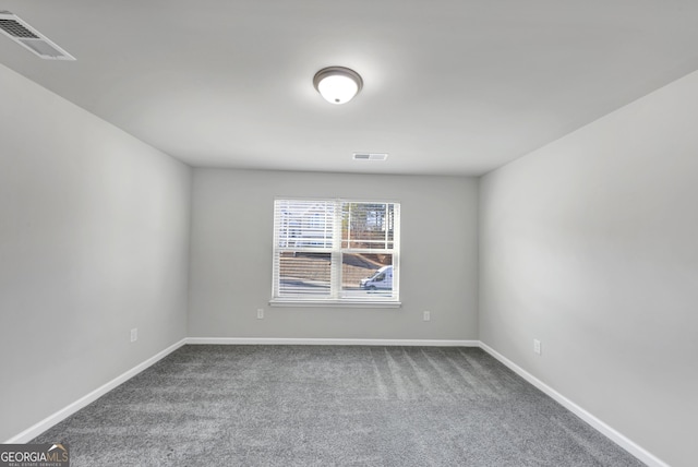 empty room featuring carpet floors, visible vents, and baseboards