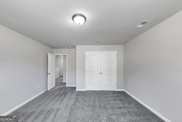 unfurnished bedroom with baseboards, a closet, visible vents, and carpet flooring