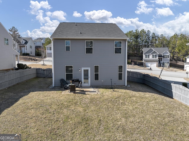 back of house featuring a yard, a fenced backyard, and a residential view