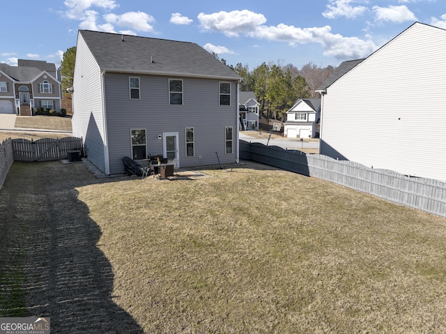 back of house with a lawn, cooling unit, a fenced backyard, and a residential view