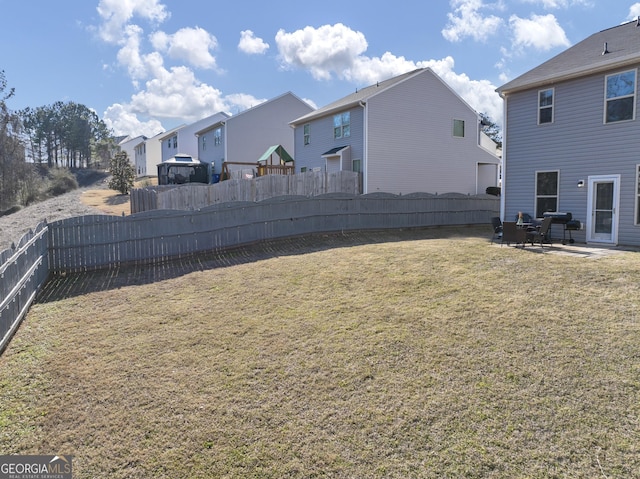 view of yard featuring a patio area, a fenced backyard, and a residential view