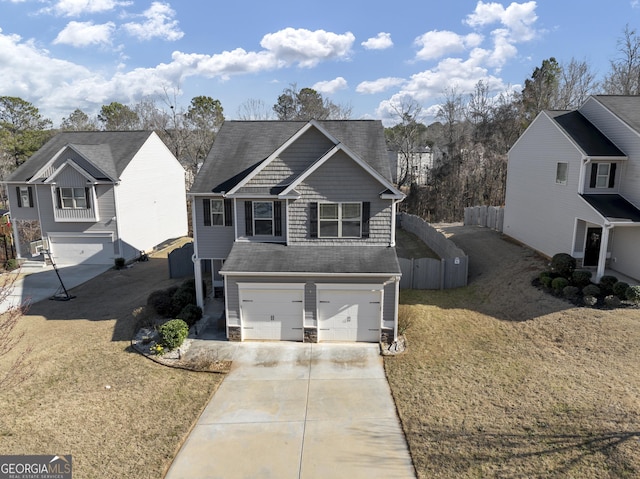 traditional-style home featuring concrete driveway, fence, and an attached garage