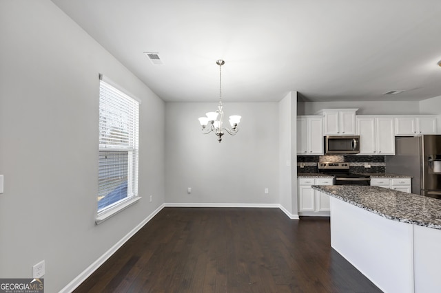 kitchen featuring stainless steel appliances, visible vents, white cabinetry, tasteful backsplash, and dark wood finished floors