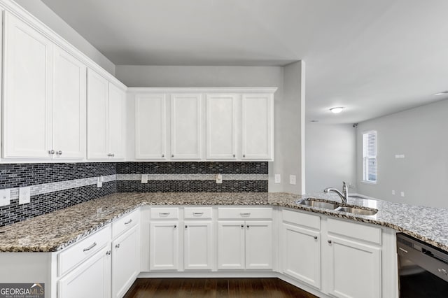 kitchen with black dishwasher, white cabinets, a sink, and decorative backsplash