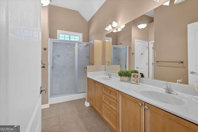 full bathroom with lofted ceiling, double vanity, a stall shower, and a sink