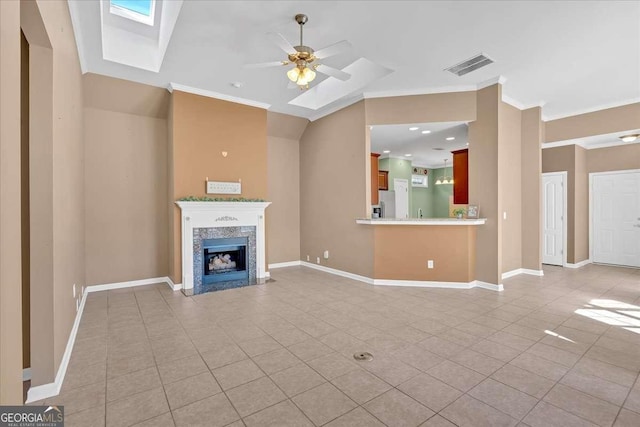 unfurnished living room with a skylight, a fireplace, visible vents, and crown molding