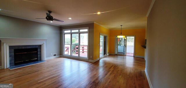 2899 Greystone Cv N, Atlanta, GA 30341 - unfurnished living room featuring crown molding, wood finished floors, baseboards, a ceiling fan, and plenty of natural light