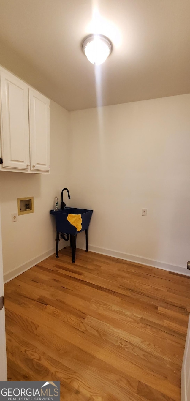 2899 Greystone Cv N, Atlanta, GA 30341 - clothes washing area with cabinet space, washer hookup, light wood-style floors, and baseboards