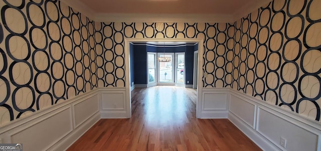 2899 Greystone Cv N, Atlanta, GA 30341 - hallway with wallpapered walls, a decorative wall, crown molding, wainscoting, and wood finished floors