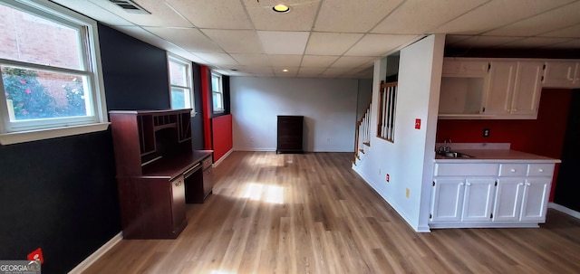 2899 Greystone Cv N, Atlanta, GA 30341 - hallway featuring baseboards, a drop ceiling, light wood finished floors, a sink, and stairs