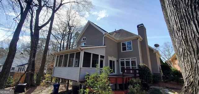 2899 Greystone Cv N, Atlanta, GA 30341 - back of property featuring a sunroom, a chimney, and stucco siding
