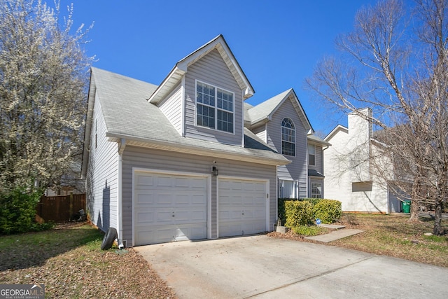 traditional-style house with a garage, fence, and concrete driveway