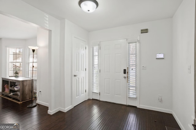 entryway with dark wood-style flooring and baseboards