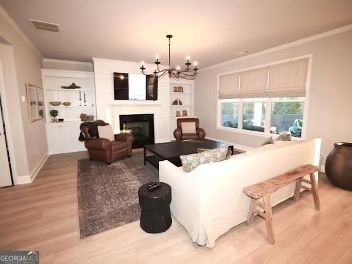 living room featuring visible vents, light wood-style floors, ornamental molding, and a fireplace