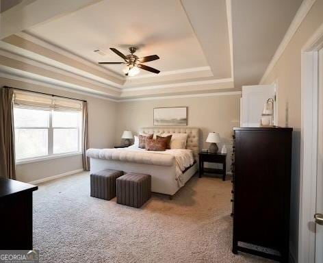 bedroom featuring a tray ceiling, carpet floors, ornamental molding, and a ceiling fan