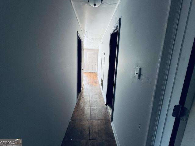 hallway with dark tile patterned flooring