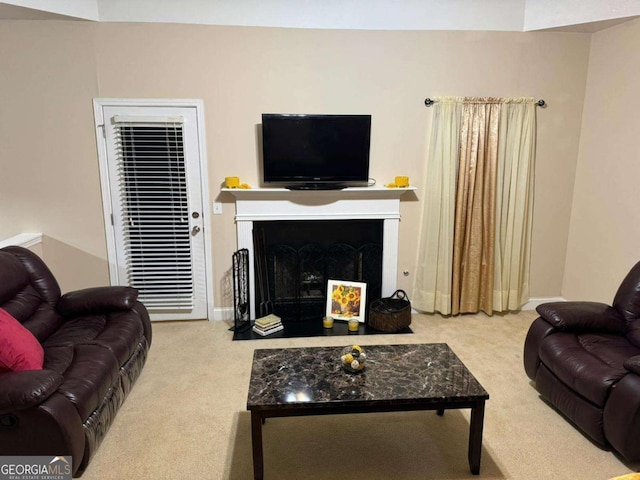 living room with a fireplace with flush hearth, carpet, and baseboards