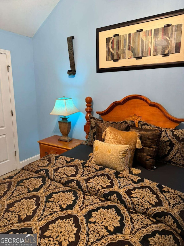 bedroom with vaulted ceiling and baseboards