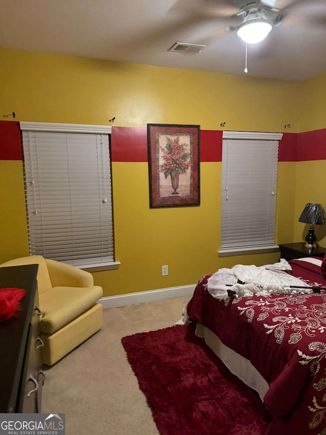 bedroom featuring carpet floors, a ceiling fan, visible vents, and baseboards