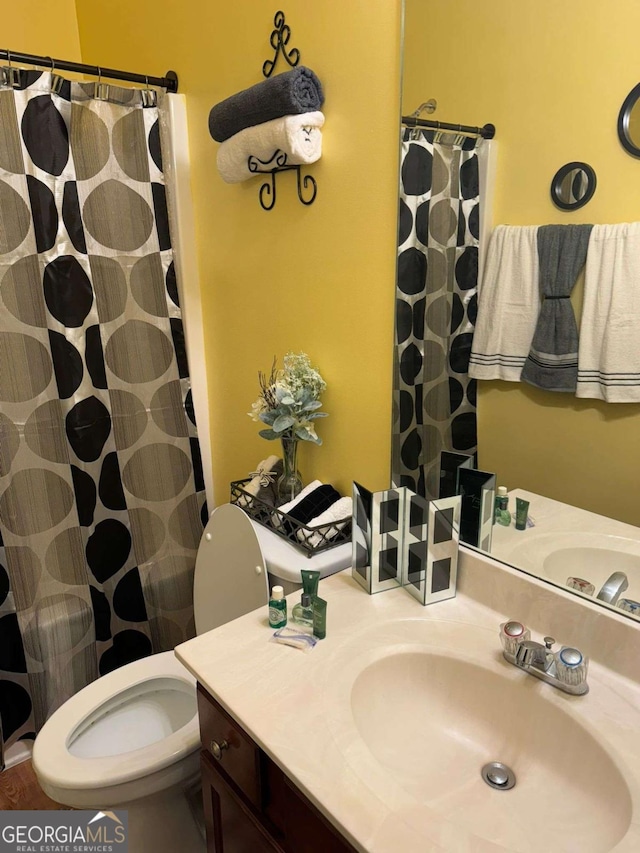 full bathroom with toilet, vanity, and a shower with curtain