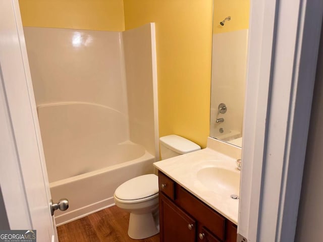 full bath with vanity, shower / bath combination, wood finished floors, and toilet