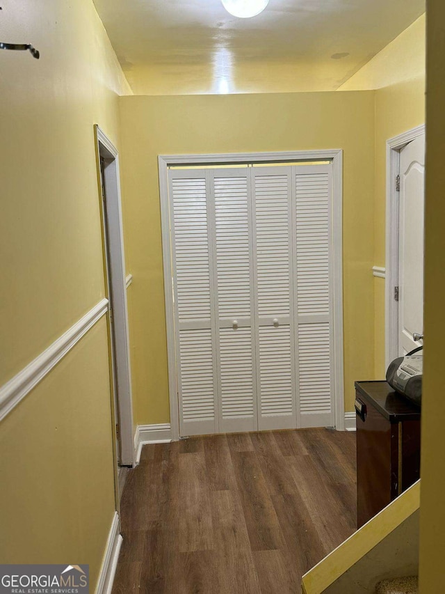 hall with baseboards and wood finished floors