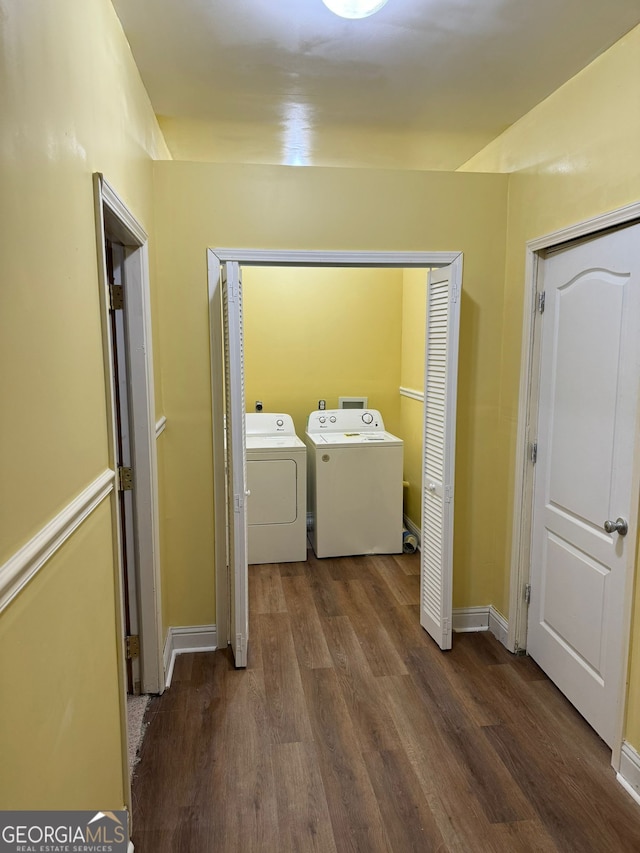 laundry area featuring baseboards, laundry area, wood finished floors, and washer and dryer