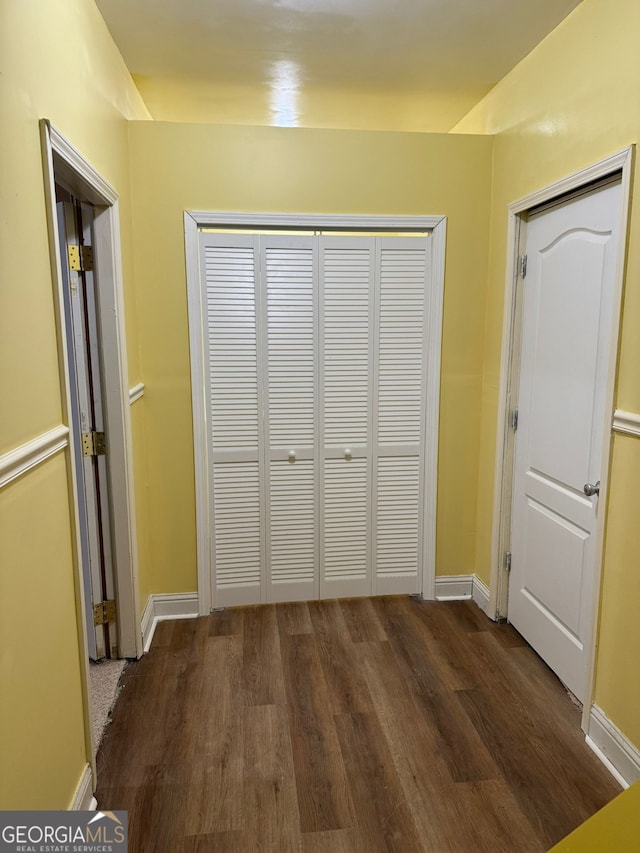 unfurnished bedroom with a closet, baseboards, and wood finished floors