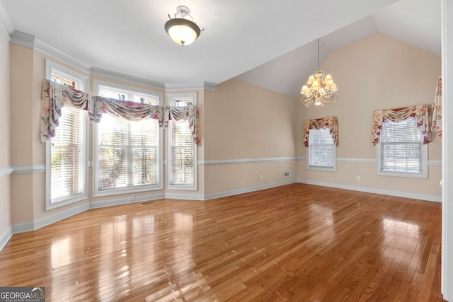 unfurnished dining area featuring a notable chandelier, baseboards, vaulted ceiling, wood-type flooring, and crown molding