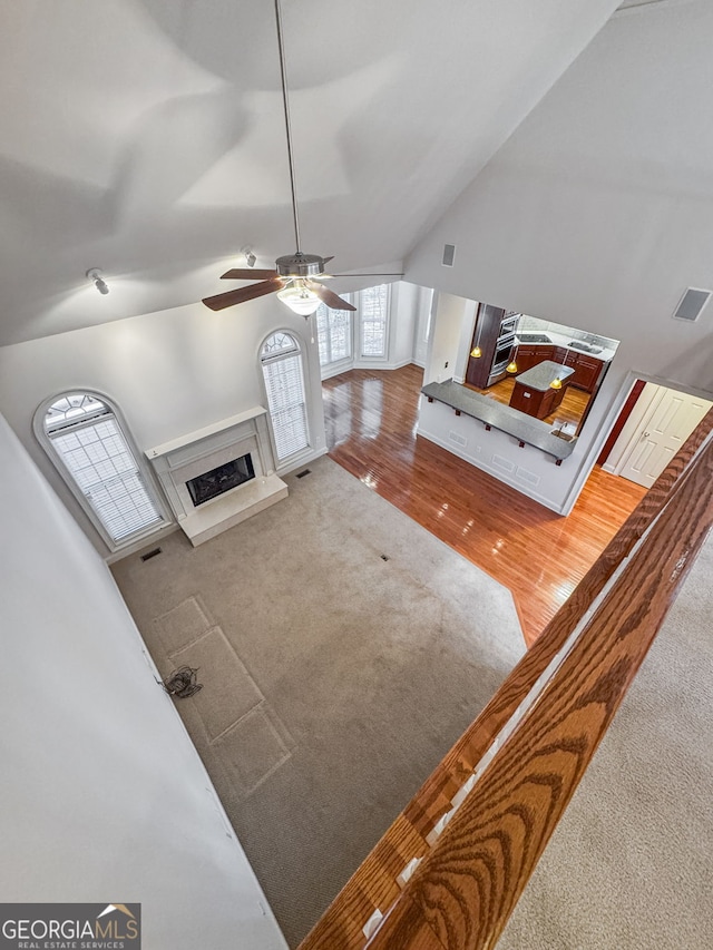 living room featuring a high end fireplace, visible vents, ceiling fan, and carpet